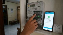Meteran listrik digital PLN dan alat pengisian token listrik prabayar di rumah.