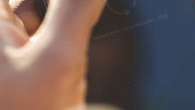 Pengguna memeriksa pengaturan keamanan akun media sosial pada ponsel untuk mencegah peretasan dan pencurian identitas digital.