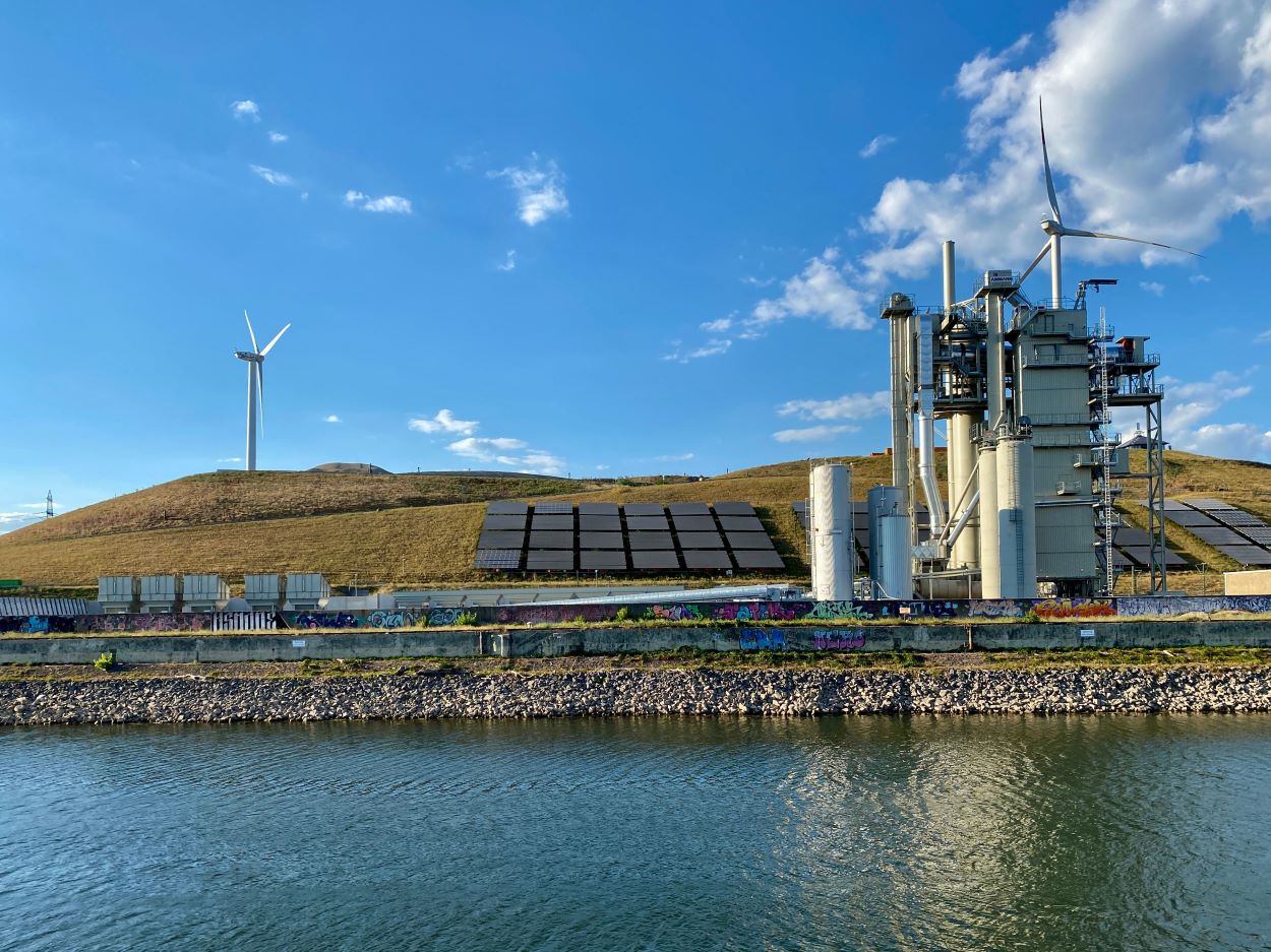 Panel surya dan turbin angin sebagai gambaran transisi energi global menuju sistem energi rendah emisi.